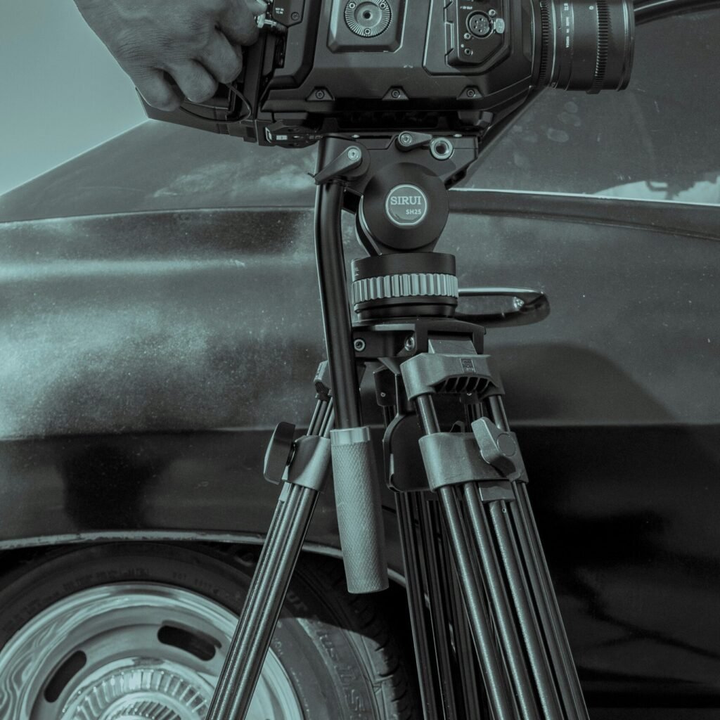 a person holding a camera next to a car